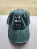 Vintage wash baseball cap with 'my gay hat' embroidered in white vintage-style font. Features a metal adjustable back and machine embroidery, designed by Carey Embroidery LLC."